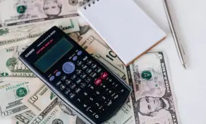 Kalkulator, notatnik i banknoty dolarów. Zastanawiam się, ile kosztuje metr sześcienny gazu, gdy ceny tak rosną.