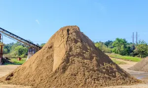 Ogromna hałda piasku na placu budowy. Zastanawiasz się, ile kosztuje tona piasku?