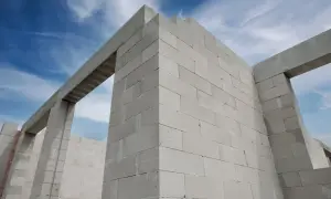 Ściany z bloczków suporeks tworzą zarys domu pod błękitnym niebem.
