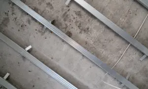 Metalowe profile do zabudowy GK zamontowane na betonowym suficie, gotowe do położenia płyt gipsowo-kartonowych.
