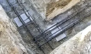 Gotowe zbrojenie fundamentów w wykopie. Stalowe pręty tworzą solidną konstrukcję, gotową na zalanie betonem.