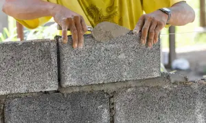 Budowniczy układa bloczki betonowe fundamentowe, tworząc solidną podstawę.
