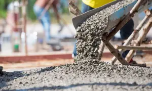 Beton wylewany z rynny na plac budowy. Zastanawiasz się, wylewka betonowa ile na m2?