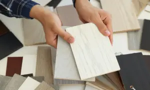 Ręce trzymają próbki materiałów, w tym jasne płyty z widocznym usłojeniem, przypominające drewno. To może być mdf, co to za materiał?