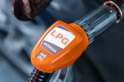 Pomarańczowa końcówka dystrybutora LPG z napisem "AUTOGAS". Rozważasz koszt instalacji gazowej?