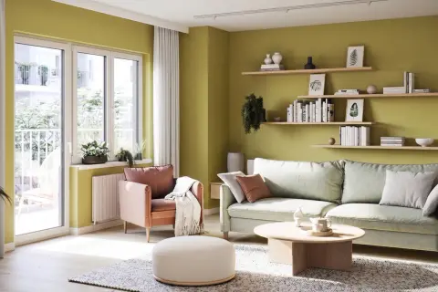 Jasnozielone, modne kolory ścian tworzą przytulną atmosferę w salonie z pastelową sofą i fotelem.