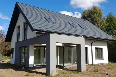 Nowoczesny dom 120 m² z szarym dachem i dużymi oknami. Zastanawiasz się, jaki koszt budowy domu 120 m²?