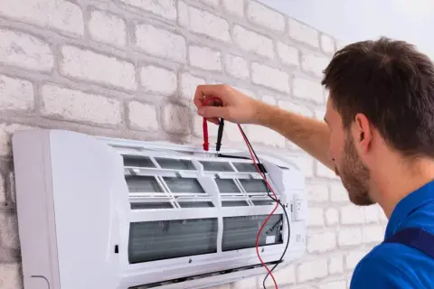 Technik sprawdza klimatyzację. Dowiedz się, ile kosztuje serwis klimatyzacji, aby zapewnić jej sprawność.