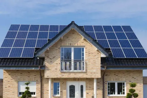 Nowoczesny dom z instalacją fotowoltaiczną 5 kW na dachu. Sprawdź instalacja fotowoltaiczna 5 kw cena z montażem.