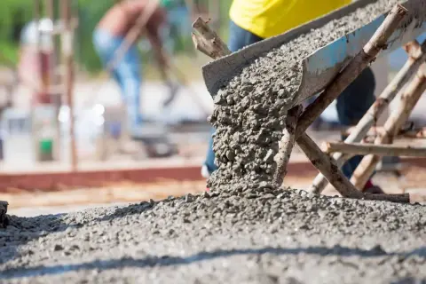 Beton wylewany z rynny na plac budowy. Zastanawiasz się, wylewka betonowa ile na m2?
