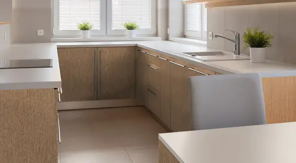Nowoczesna kuchnia z frontami szafek w naturalnej okleinie dębowej. Jasne blaty i minimalistyczne uchwyty.