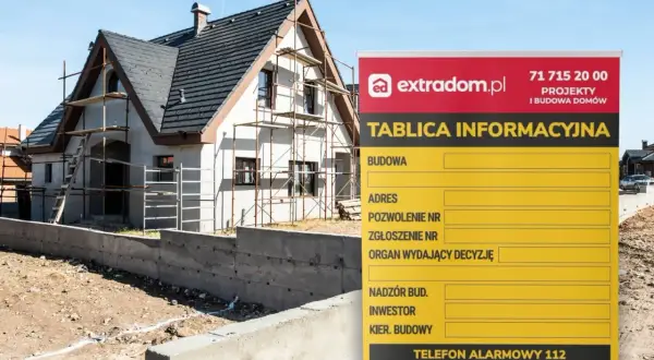 Tablica informacyjna budowy domu w trakcie prac, z widocznym rusztowaniem i fundamentami. Na tablicy dane projektu i numery alarmowe.