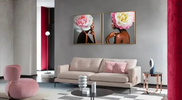 Nowoczesny salon z dwoma obrazami kobiet z kwiatami na głowach. W tle widać meble w odcieniach beżu i różu, a także akcenty w kolorze magenta.
