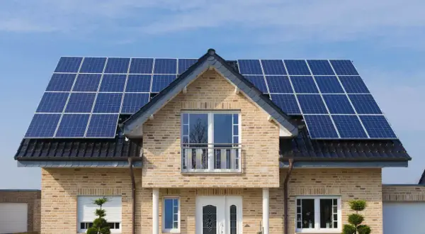 Nowoczesny dom z instalacją fotowoltaiczną 5 kW na dachu. Sprawdź instalacja fotowoltaiczna 5 kw cena z montażem.