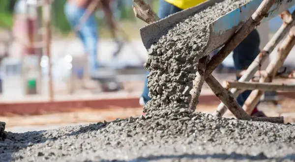 Beton wylewany z rynny na plac budowy. Zastanawiasz się, wylewka betonowa ile na m2?