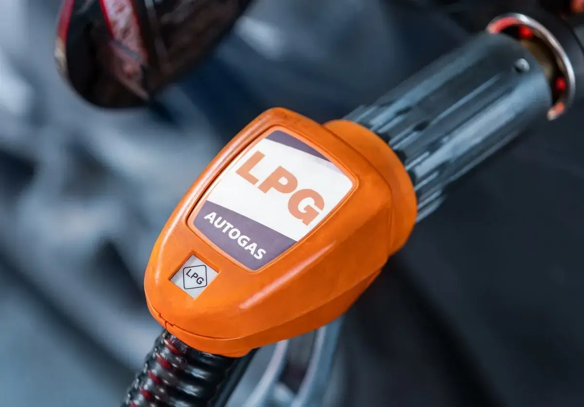Pomarańczowa końcówka dystrybutora LPG z napisem "AUTOGAS". Rozważasz koszt instalacji gazowej?