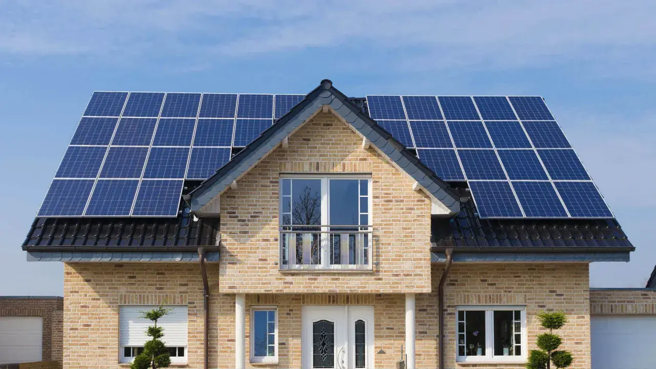 Nowoczesny dom z instalacją fotowoltaiczną 5 kW na dachu. Sprawdź instalacja fotowoltaiczna 5 kw cena z montażem.