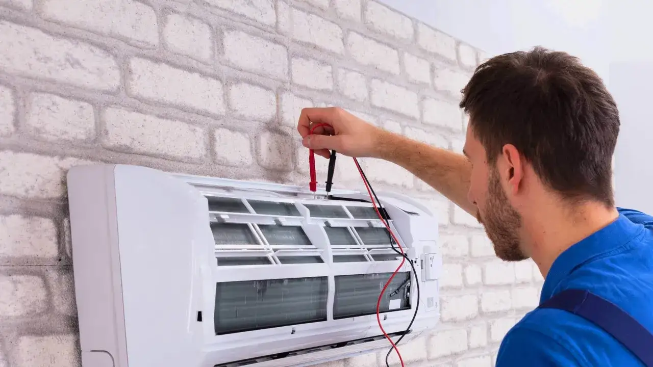 Technik sprawdza klimatyzację. Dowiedz się, ile kosztuje serwis klimatyzacji, aby zapewnić jej sprawne działanie.