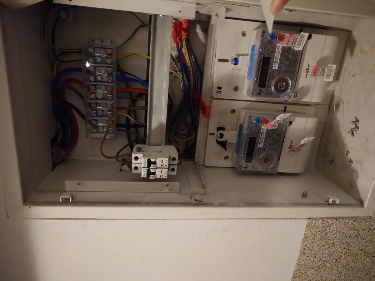 W skrzynce elektrycznej widoczne są liczniki energii oraz zabezpieczenie przedlicznikowe.