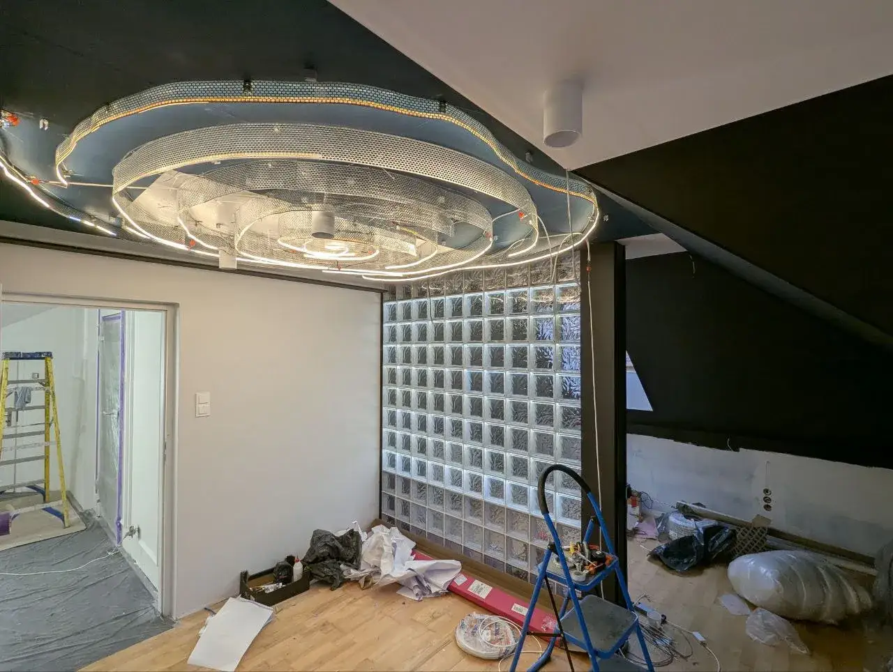 Nowoczesne wnętrze w trakcie remontu, z nietypowym sufitem i ścianą z pustaków szklanych. Zastanawiasz się, ile zarabia architekt wnętrz?