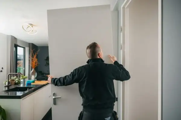 Fachowiec montuje drzwi wewnętrzne. Sprawdź, jaka jest montaż drzwi wewnętrznych cena.